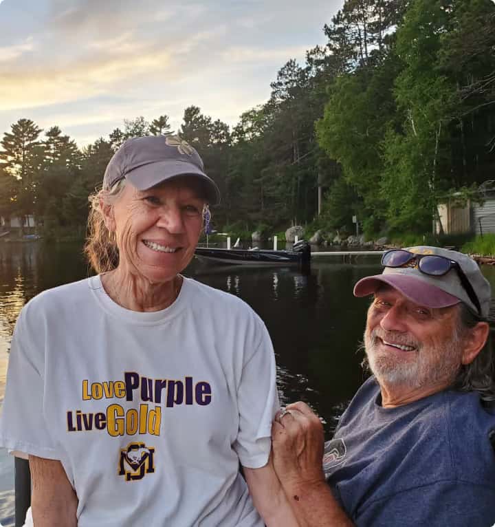 husband and wife in front of lake 