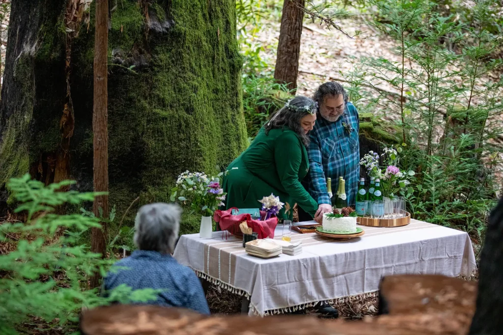 kathryn and joey at their forest wedding cutting the cake at their tree
