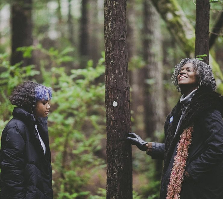 a mom and daughter pick out a memorial tree in the forest