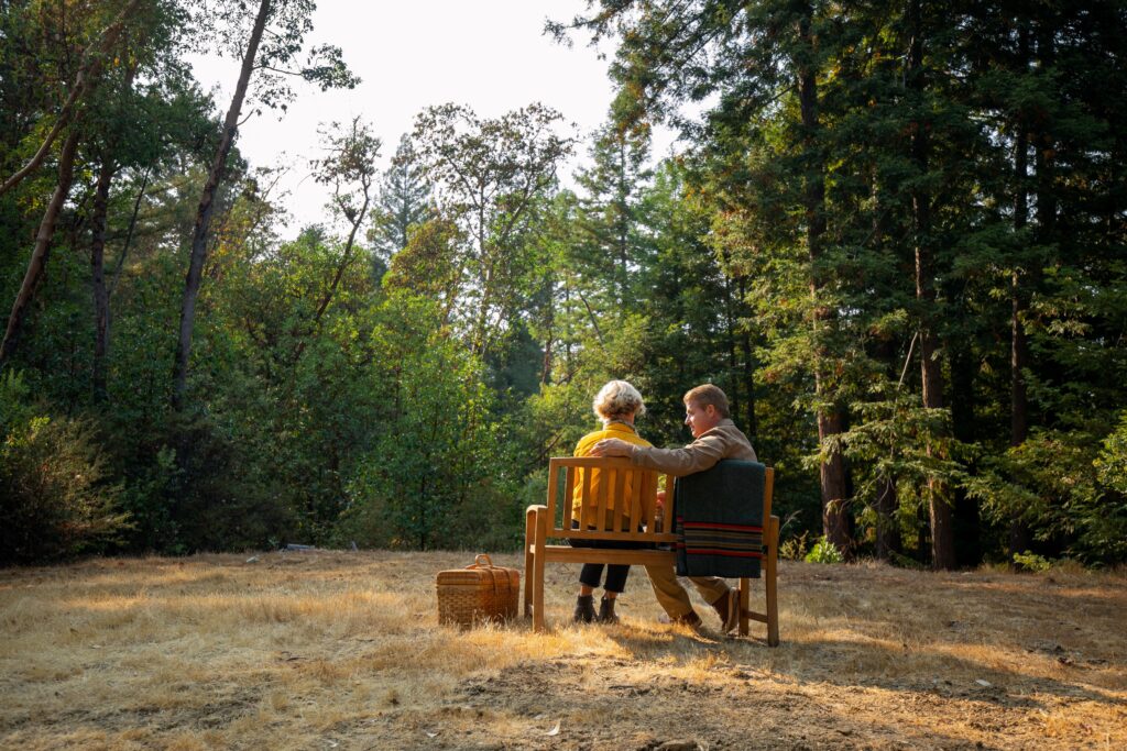 the back of a couple sitting on a bench after a memorial